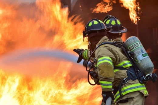 Twee brandweerlieden dichtbij de vlammen tijdens een blussing