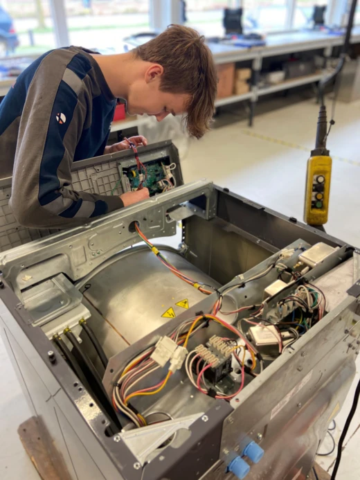 Technicus werkt aan het binnenwerk van een wasmachine