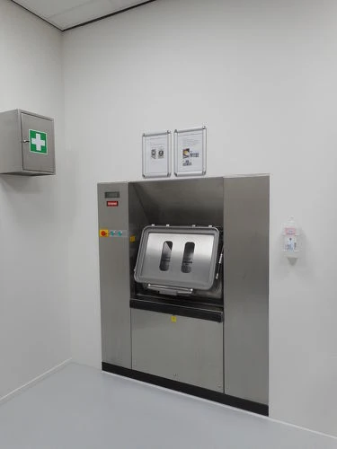 Barrièrewasmachine aan de schone zijde van een wasserij