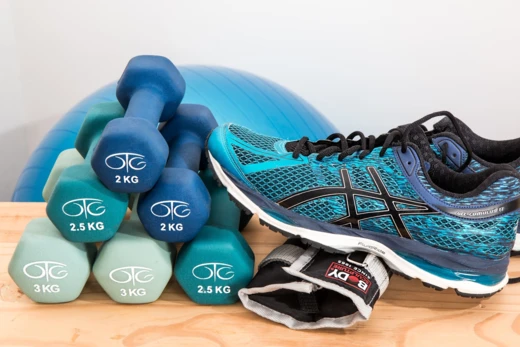 Sportartikelen: halters, een fitnessbal en hardloopschoenen