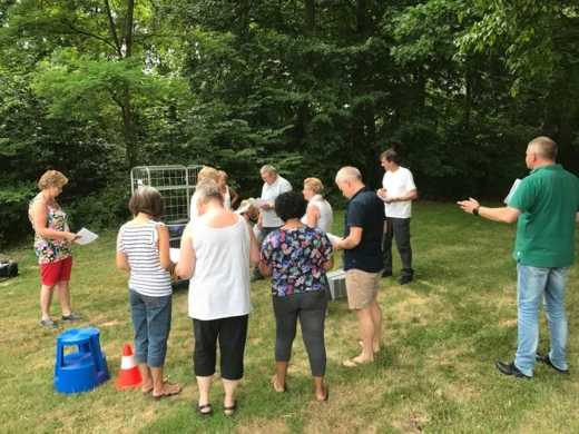 Groep mensen buiten rond een wasmand tijdens een activiteit