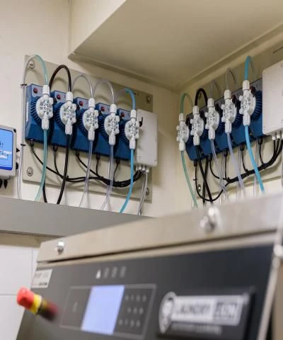 Doseerpompen voor wasmiddel aangesloten op een professionele wasmachine