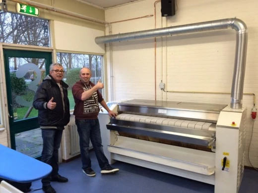 Twee mannen met duim omhoog bij een nieuw geplaatste mangel