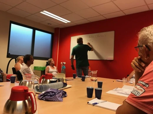 Trainer geeft uitleg op een whiteboard tijdens een training