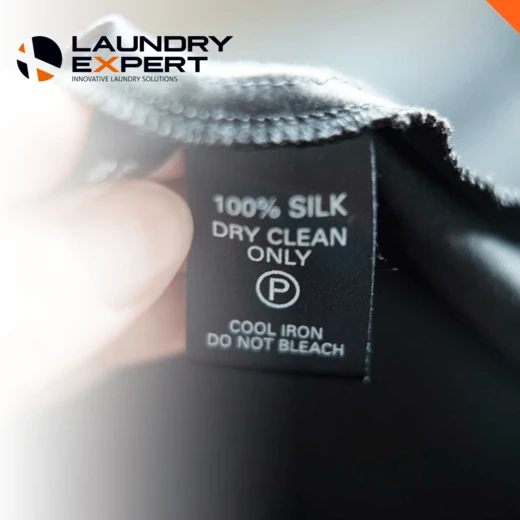 Close-up van een kledinglabel met "100% silk, dry clean only"
